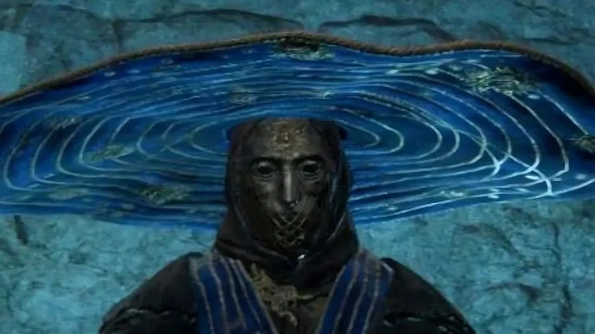 Elden Ring: Where to Find Seluvis's Secret Puppet Room Seluvis-from-Elden-Ring-wearing-a-blue-and-gold-hat